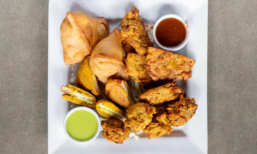 Assorted Vegetable Platter &mdash; veg samosa, vegetable pakoras and paneer pakoras with chutneys at Haandi Indian Cuisine in Bowness, Calgary